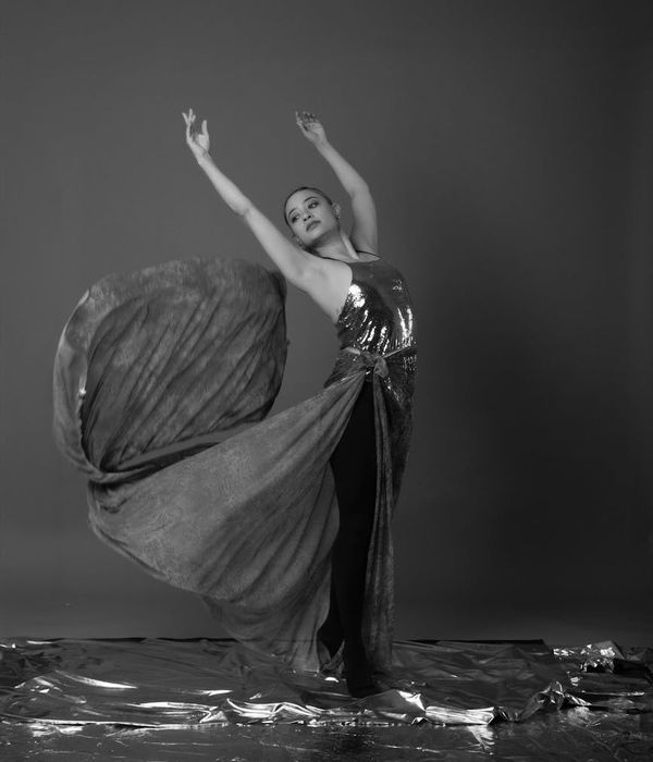 Woman performing a fluid cardio movement in a calm studio setting.